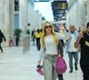 Virgínia apostou em uma composição urbana e confortável para viajar: blusa branca ajustada, jeans estonado wide leg e tênis esportivo chunky