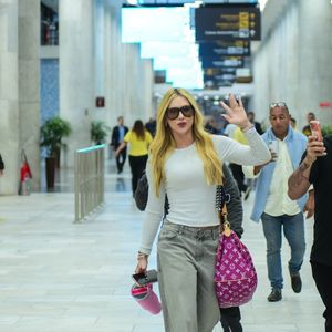 Virgínia apostou em uma composição urbana e confortável para viajar: blusa branca ajustada, jeans estonado wide leg e tênis esportivo chunky