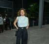 Débora Bloch vestiu uma blusa branca de gola alta sem mangas com caimento levemente drapeado no peito. Ela combinou a peça superior com uma calça jogger preta de cintura alta com cinto e ajuste na barra no estilo streetwear. Para fechar o look moderno e confortável, a atriz usou tênis esportivos robustos e uma bolsa tiracolo preta