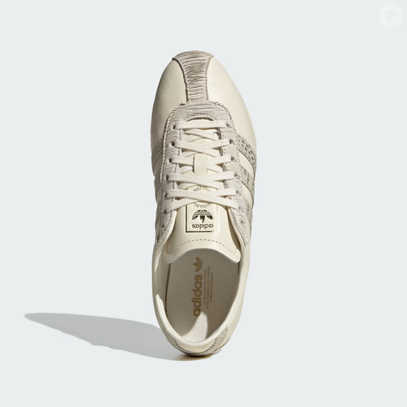 A tonalidade de nata montada do Adidas Tokyo é uma alternativa para quem deseja variar os tênis brancos e apostar em uma cor neutra que conversa com diferentes estilos, especialmente nas combinações com jeans, camisas e peças de alfaiataria