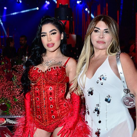 A mãe da funkeira optou por um vestido branco justo e transparente, adornado com apliques brilhantes em formato floral, complementado por uma bolsa prata da Gucci e sandália de salto. Duas gerações unidas pelo glamour na noite mais ousada do ano
