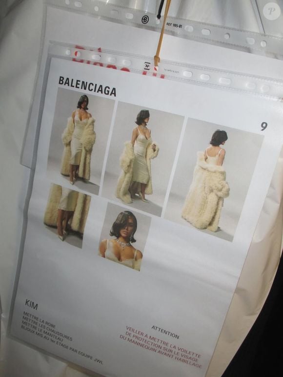 Para a ocasião, Kardashian vestiu um modelo midi justo em tom marfim, adornado com detalhes em renda delicada e finalizado com um casaco de pele combinando, usado sobre os ombros.