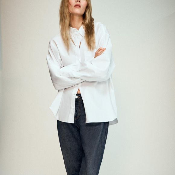 Com fechamento frontal por botões, a Camisa de Popelina com Bolso da Zara aposta em uma modelagem clássica, mangas amplas e tecido principal de algodão 100%