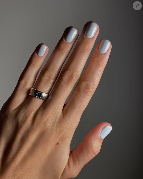 Unhas com tonalidade azul pastel de fundo acinzentado trazem um ar refinado e mais ousado para suas mãos.