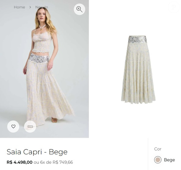A saia Capri, da NV, tem comprimento longo e se destaca pelo cós largo com aplicações de discos e detalhes metálicos