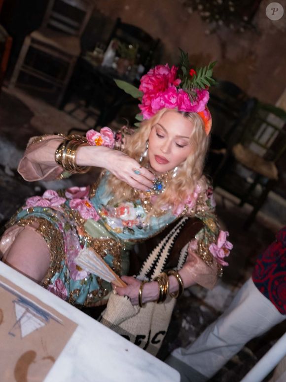 Para a primeira produção de seu aniversário de 68 anos, Madonna escolheu um vestido azul estampado da Dolce&Gabbana, combinando flores rosas e detalhes dourados