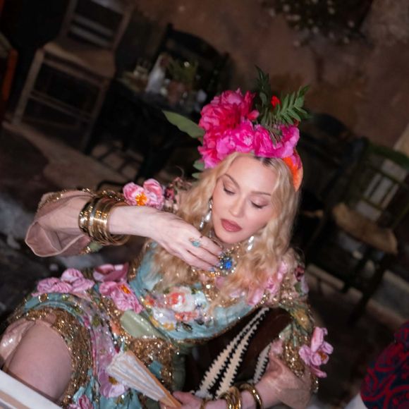 Para a primeira produção de seu aniversário de 68 anos, Madonna escolheu um vestido azul estampado da Dolce&Gabbana, combinando flores rosas e detalhes dourados