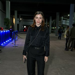 Alice Wegmann: aposta em um look all black elegante composto por camisa social de cetim, calça pantalona de alfaiataria com cinto fino, bolsa tiracolo de corrente e sapatos pretos