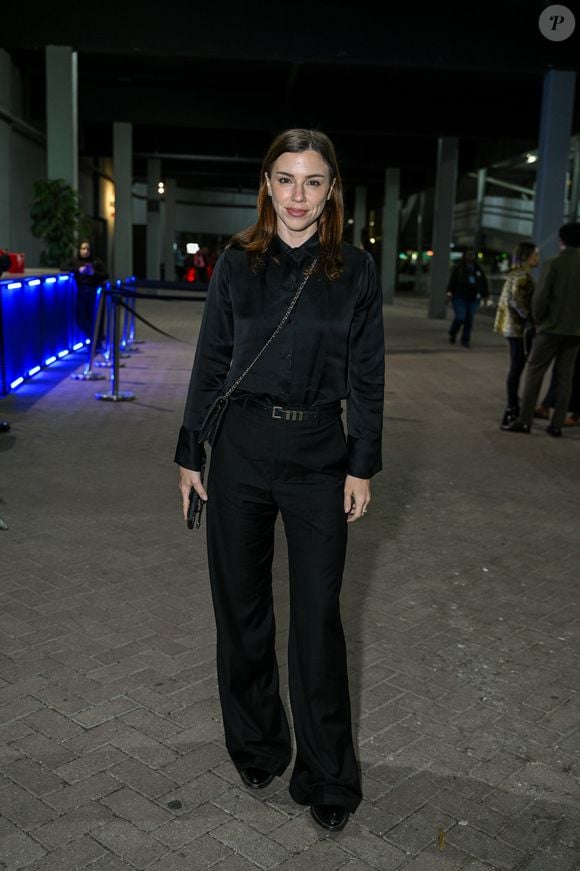 Alice Wegmann: aposta em um look all black elegante composto por camisa social de cetim, calça pantalona de alfaiataria com cinto fino, bolsa tiracolo de corrente e sapatos pretos