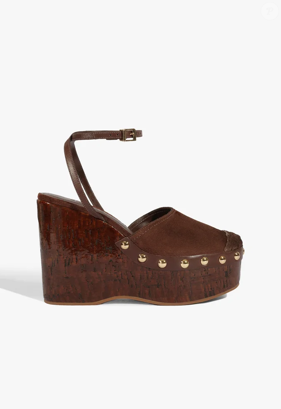 A sandália plataforma de suede marrom da Schutz resgata a estética dos anos 70 com plataforma de cortiça de 11,5 cm e tachas douradas