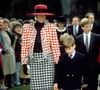 Princesa Diana apostou em um conjunto de terno e saia da Moschino, com estampa pied-de-poule em vermelho e branco, no batizado da Princesa Eugenie, em dezembro de 1990. O scarpin bicolor, com biqueira vermelha vibrante, também se destacou na produção e reforçou a elegância característica de seu estilo noventista