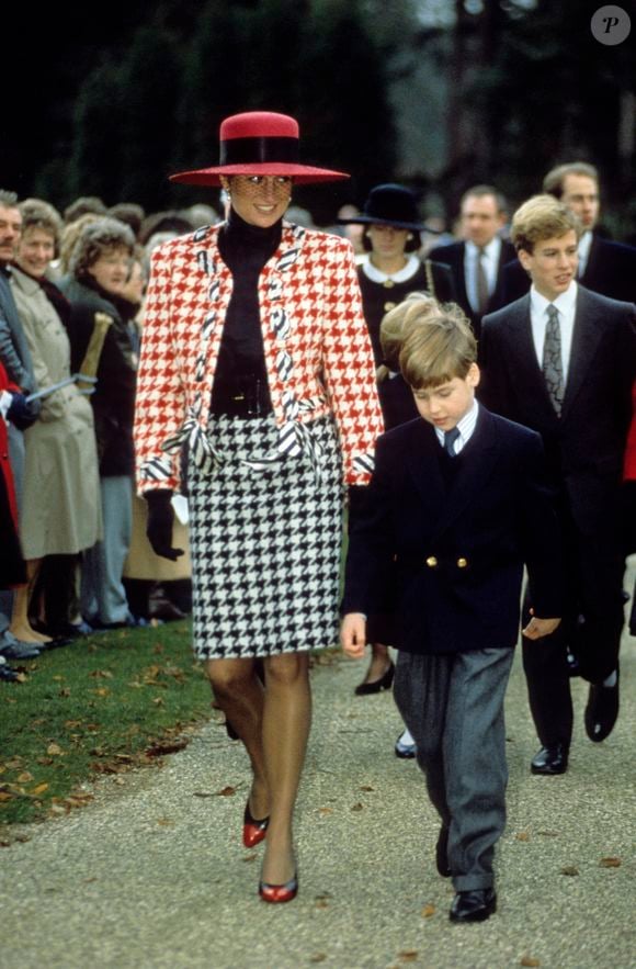 Princesa Diana apostou em um conjunto de terno e saia da Moschino, com estampa pied-de-poule em vermelho e branco, no batizado da Princesa Eugenie, em dezembro de 1990. O scarpin bicolor, com biqueira vermelha vibrante, também se destacou na produção e reforçou a elegância característica de seu estilo noventista